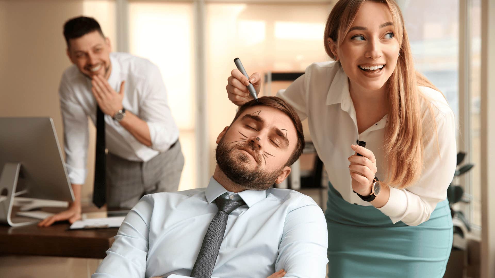 woman drawing on sleeping man's face