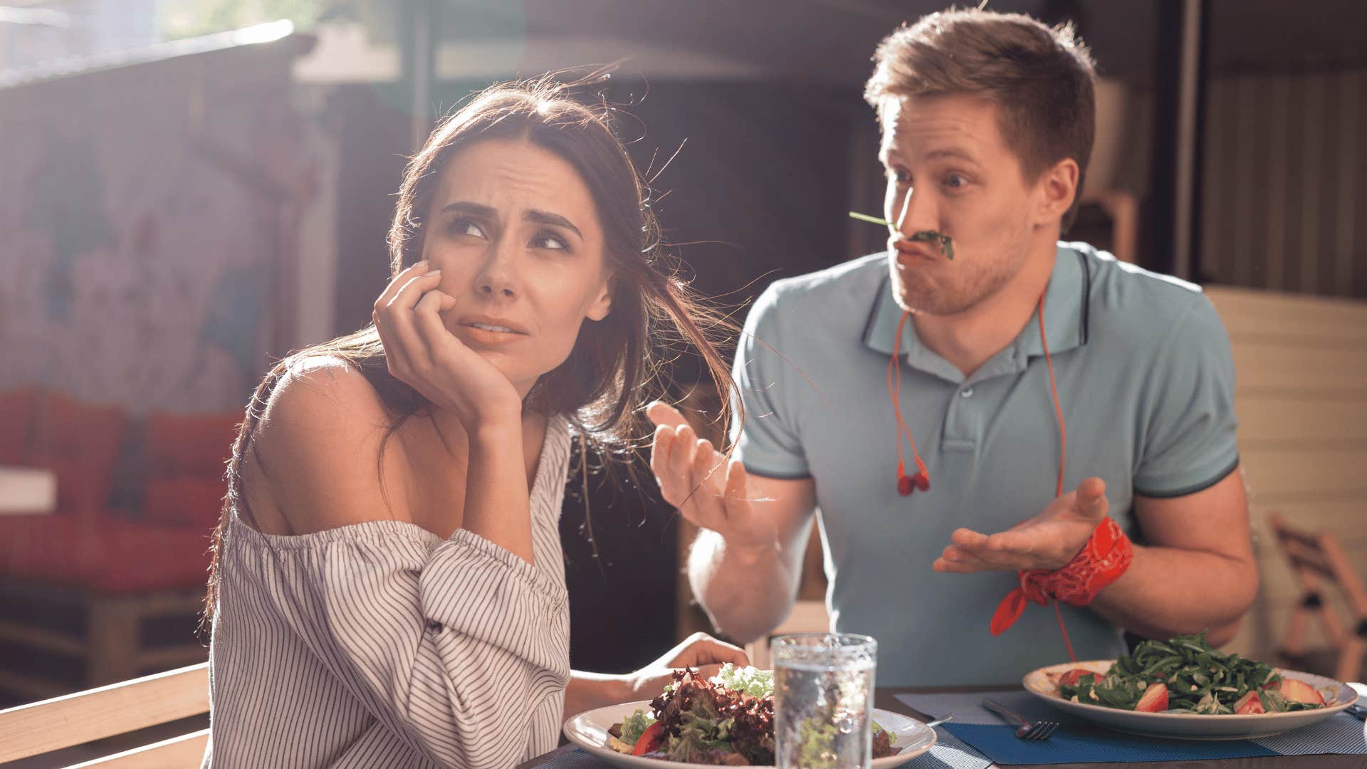 man acting silly on date with woman looking away