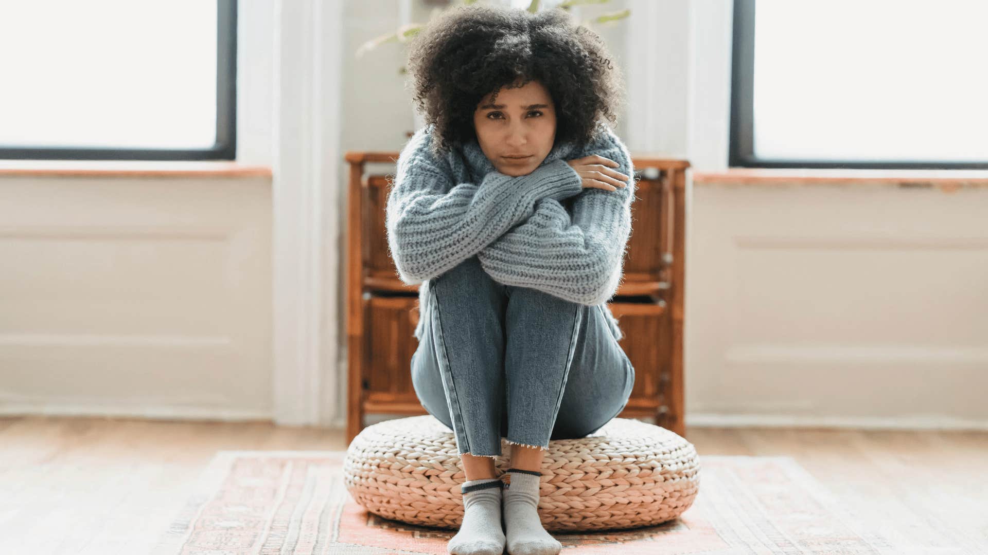 sad woman sitting with her knees to her chest