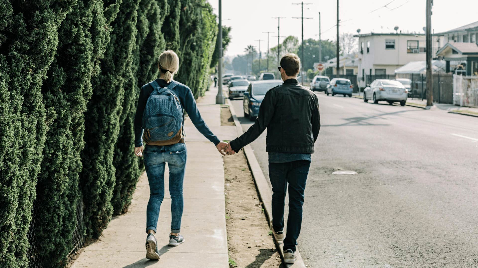 couple walking hand in hand down street