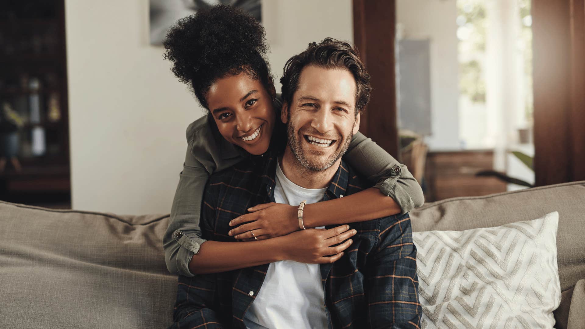 woman hugging man from behind the couch