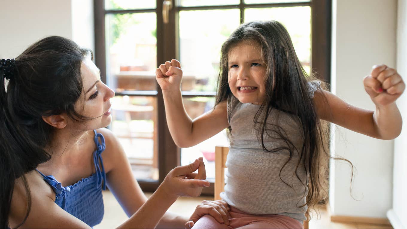 mom tries to calm reactive young daughter having a tantrum at home