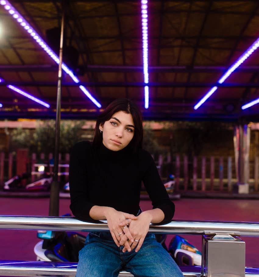 Pensive looking woman sits on carnival ride