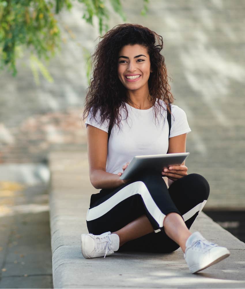 Woman with curly hair smiling while breaking multitasking habit