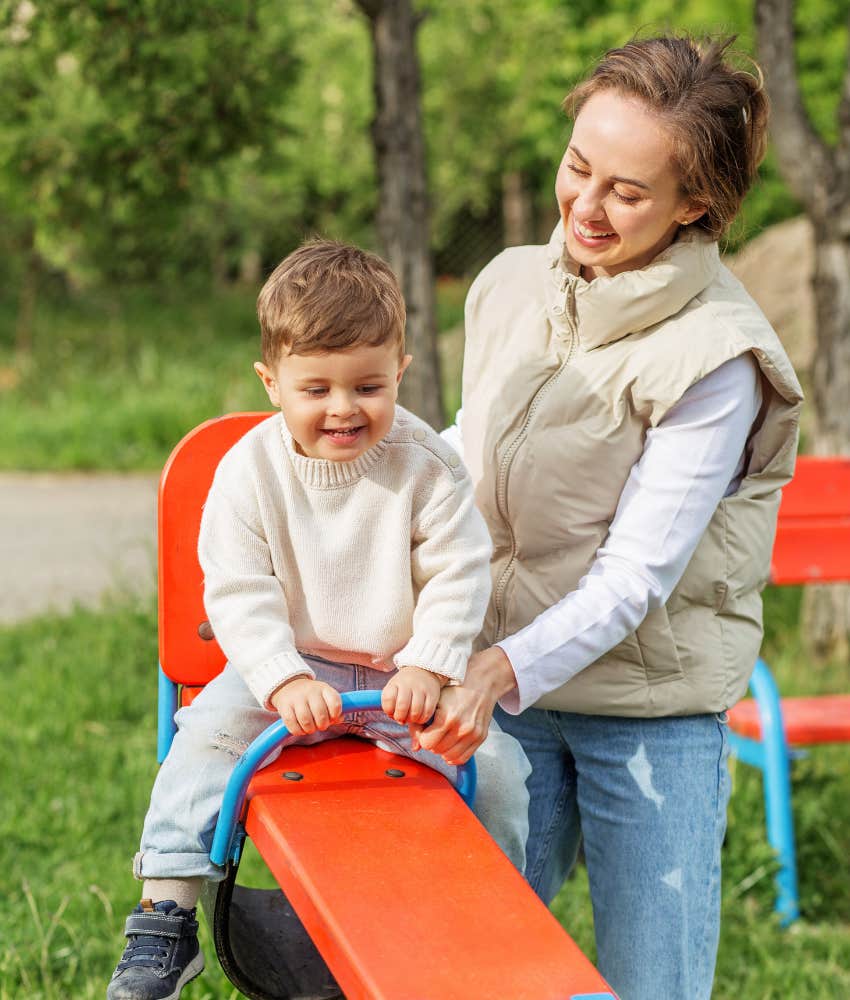 babysitter playing with little boy on playground