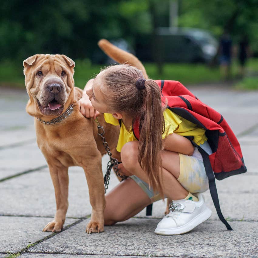 Kid saying bye to dog before going back to school