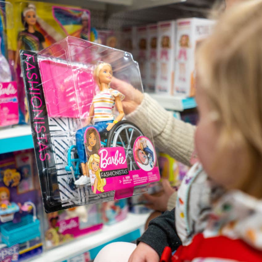 little girl with barbie doll in wheelchair 