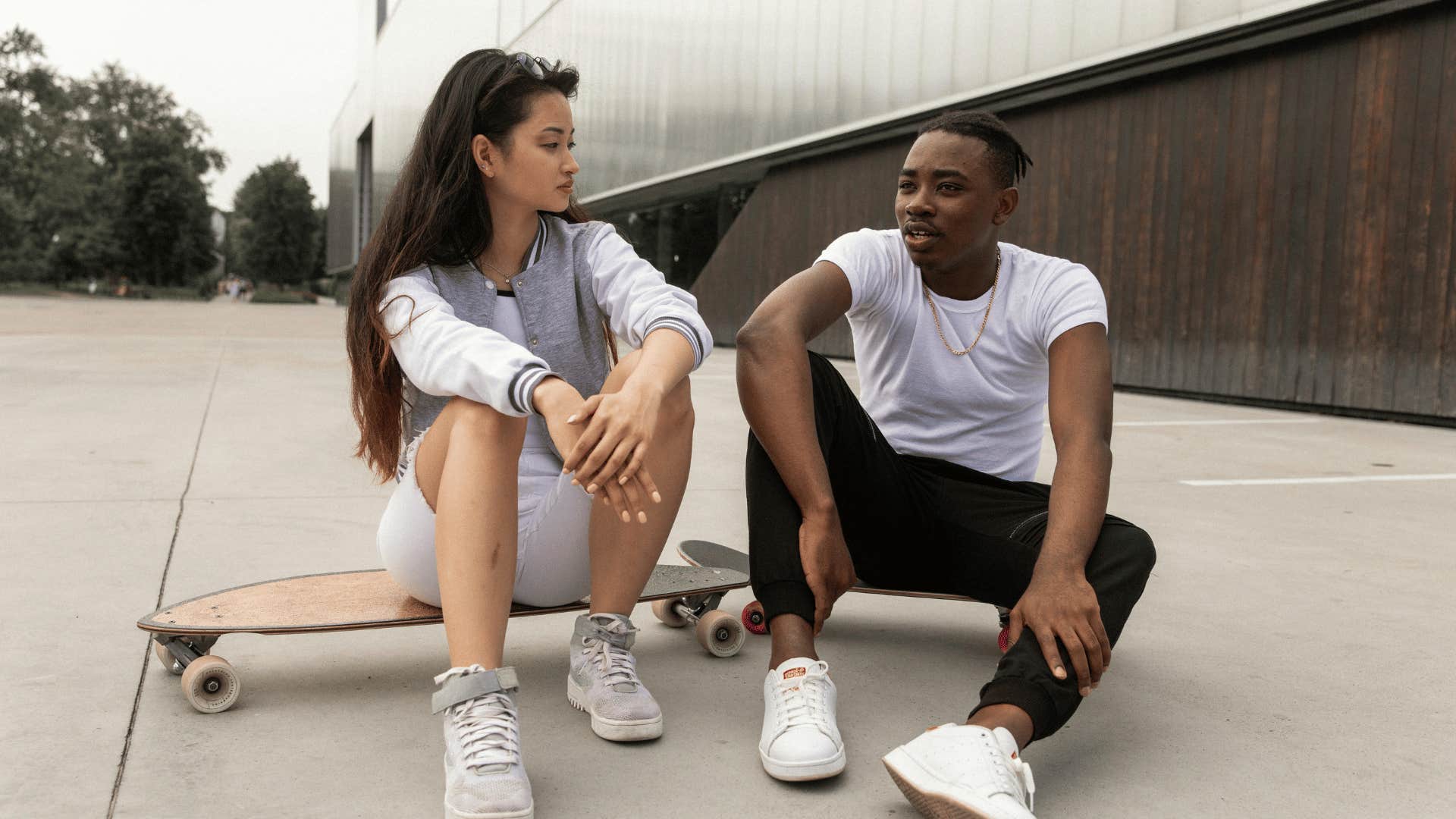 man and woman talking on skateboard