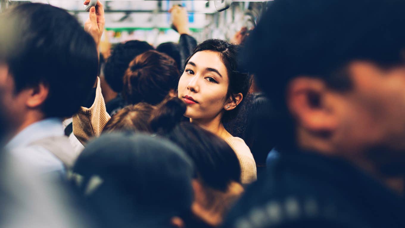 Woman standing out in a crowded bus, living the life she wants