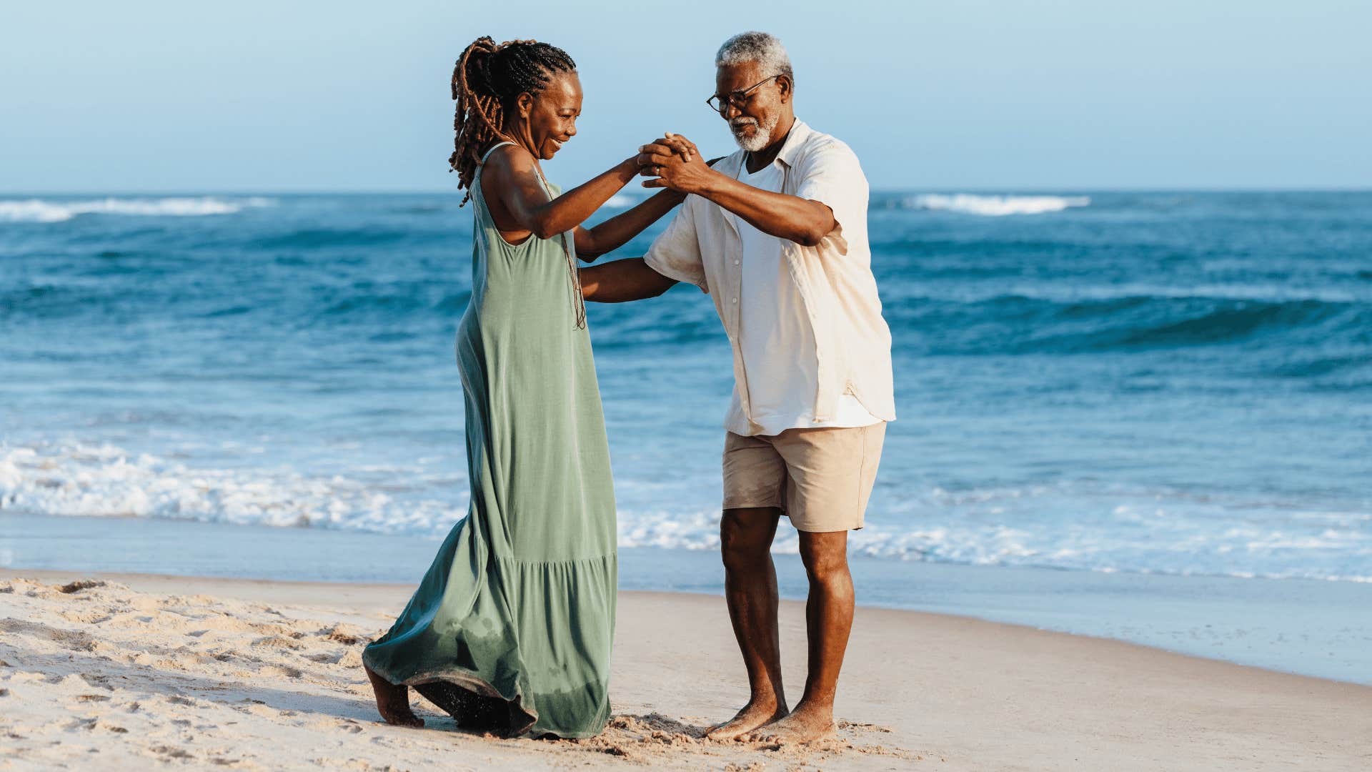 Couple dances on the sand near the ocean