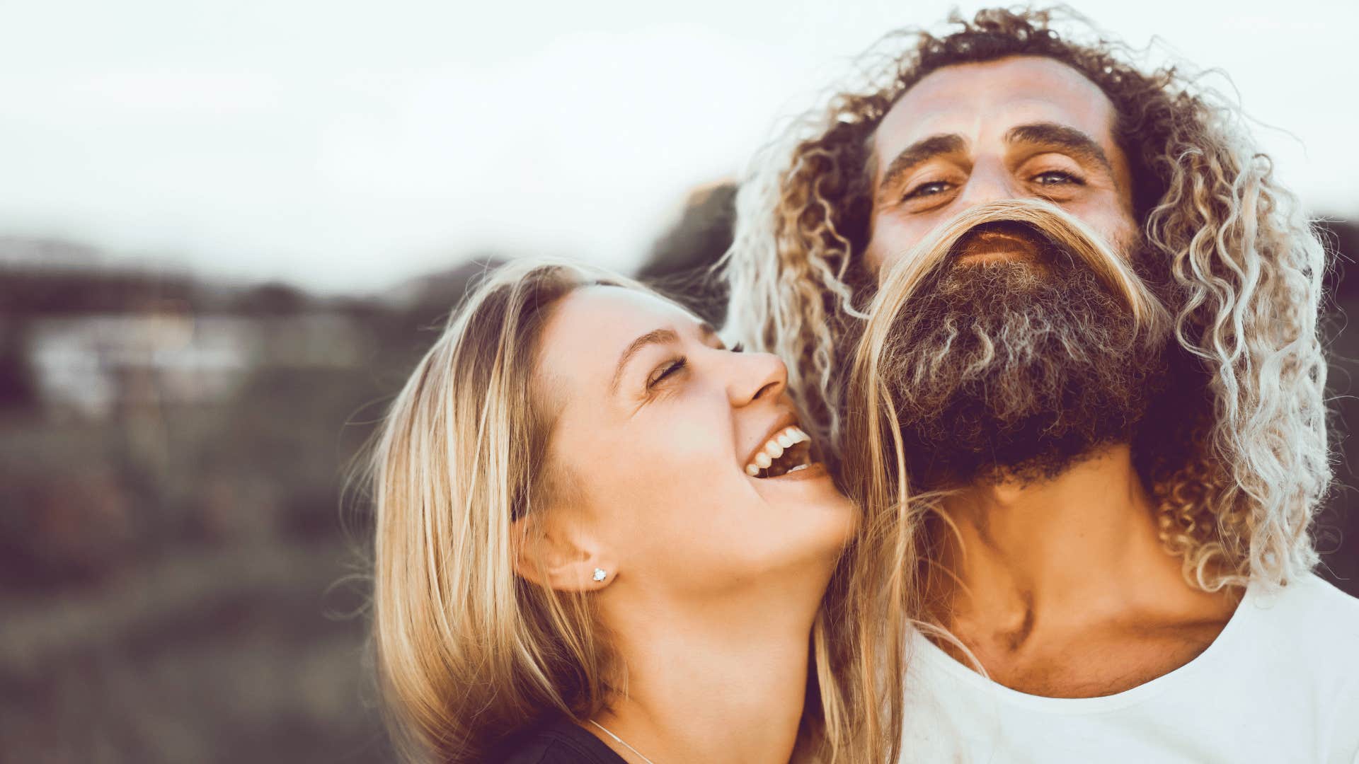 Fun couple play with hair and laugh