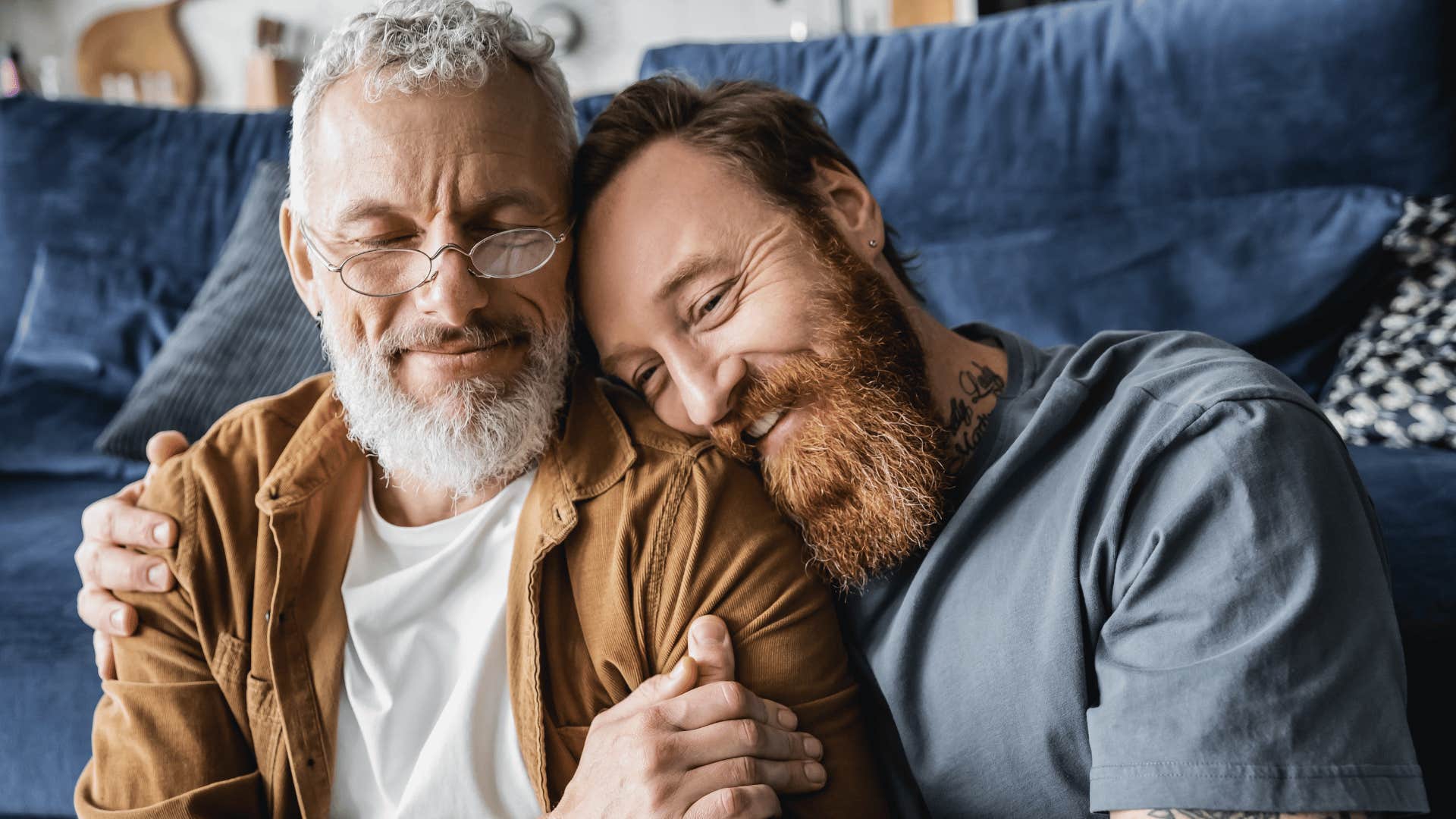 Couple comfortably cuddles and grins