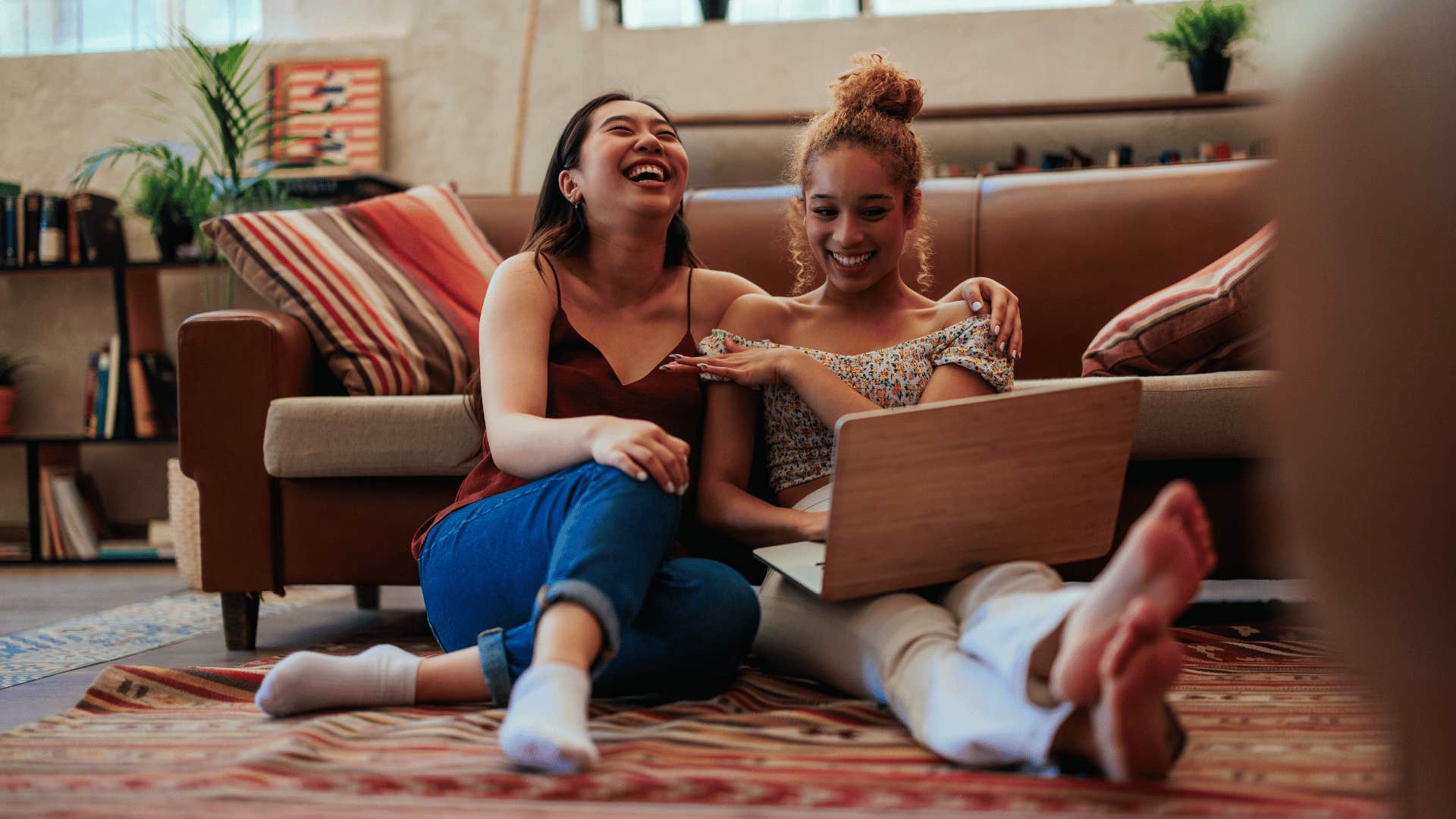 Couple laugh while while using laptop to explore shared interest