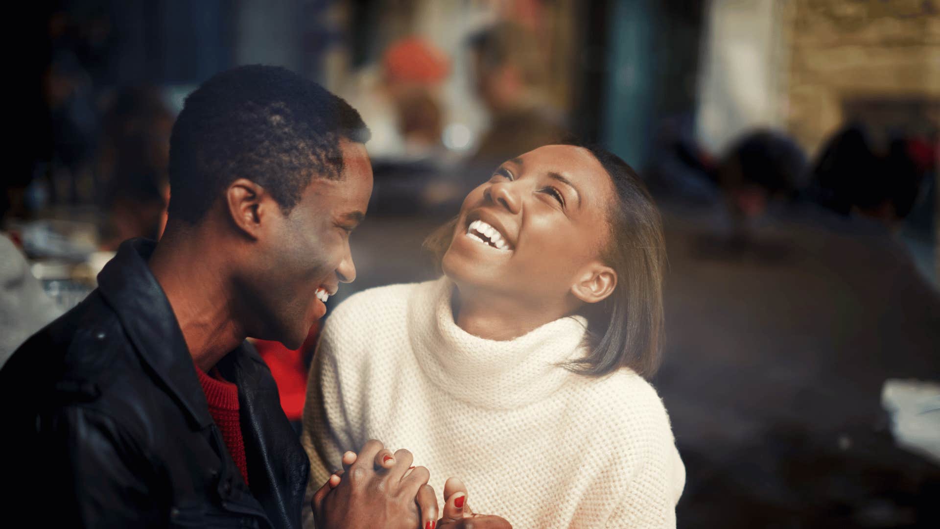 Couple in cafe laugh together