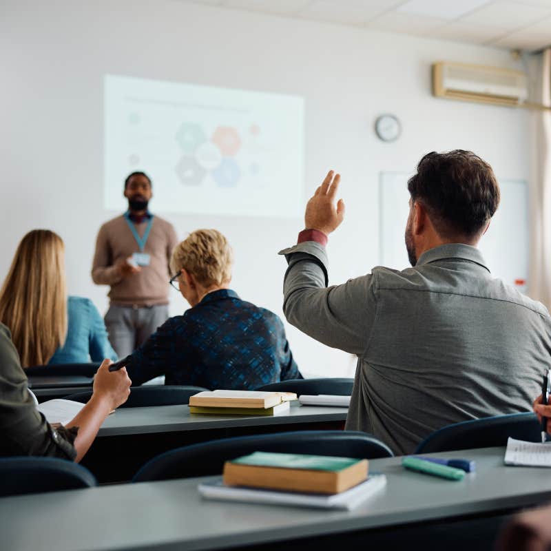 college student raising hand in class