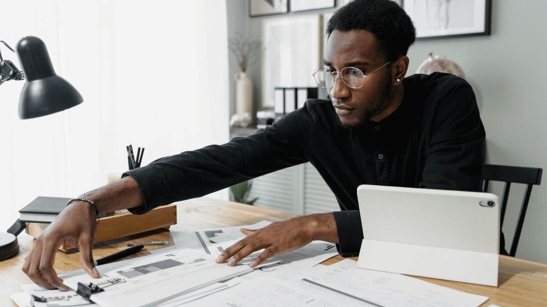 businessman looking through packets of paper on desk