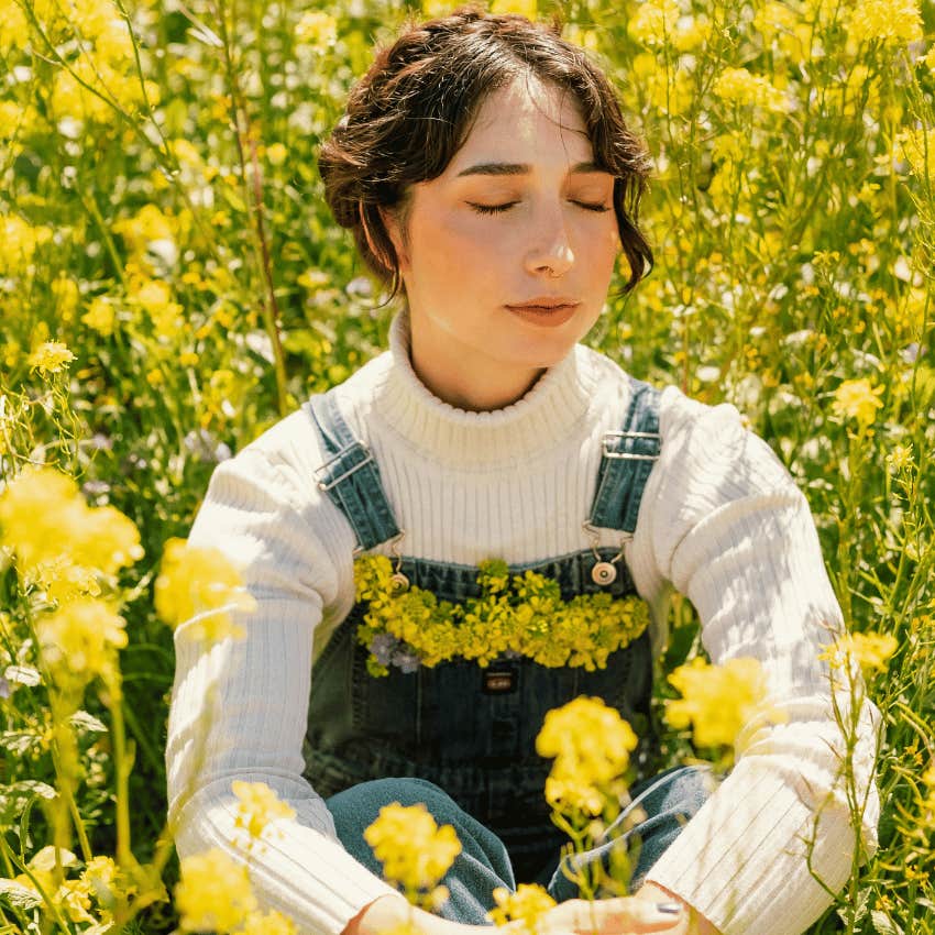 calm and peaceful woman in field of flowers