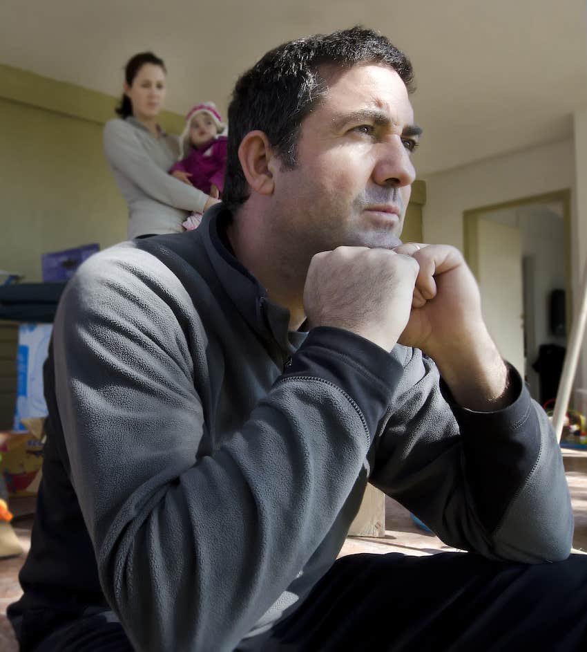 Upset man contemplates while woman behind him knows