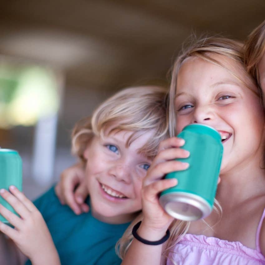 little boy and girl drinking from drink cans 