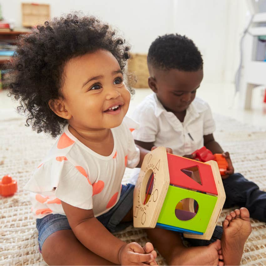 Toddlers playing with morning basket toys in the living room. 