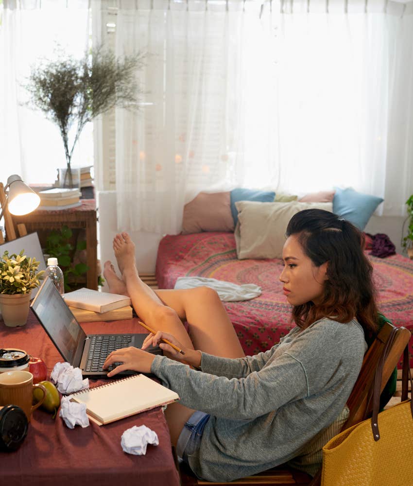 College student in dorm working on laptop