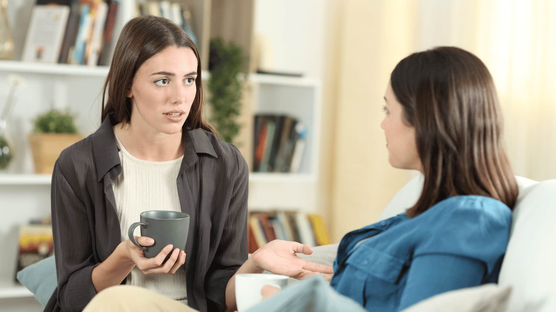 two women talking on a couch