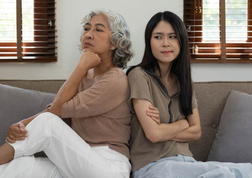 mom and grown up daughter sit on couch with conflict 