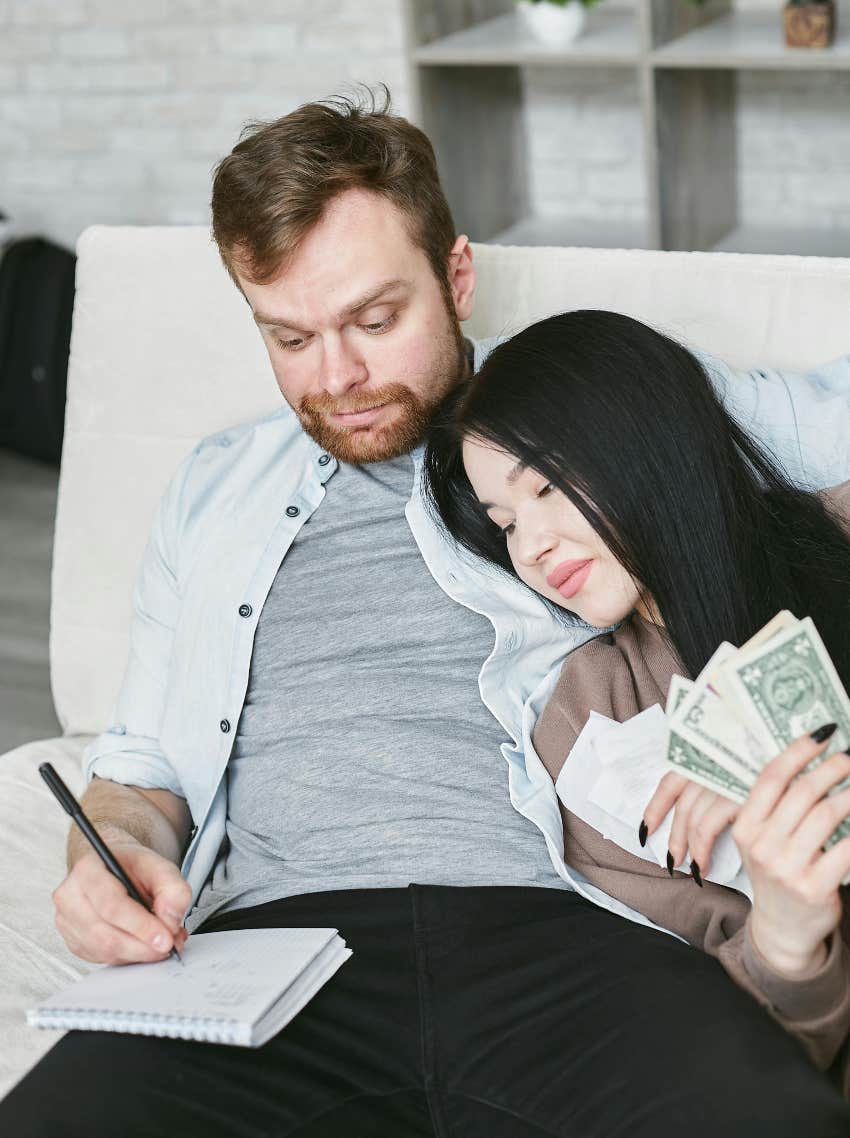 couple counting money together on the couch