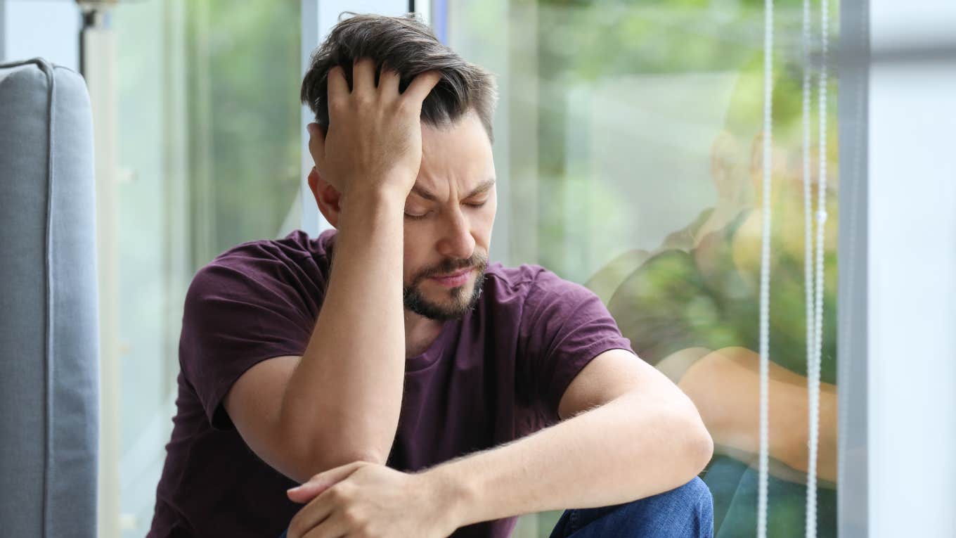 lonely and depressed man near window at home