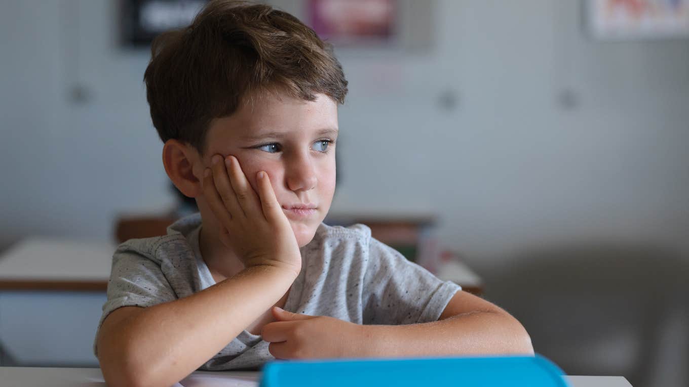 Sad young boy in school