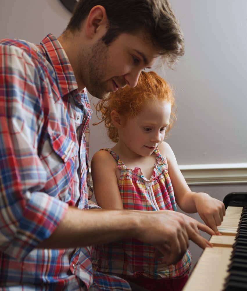 dad teaching his daughter how to play piano at home