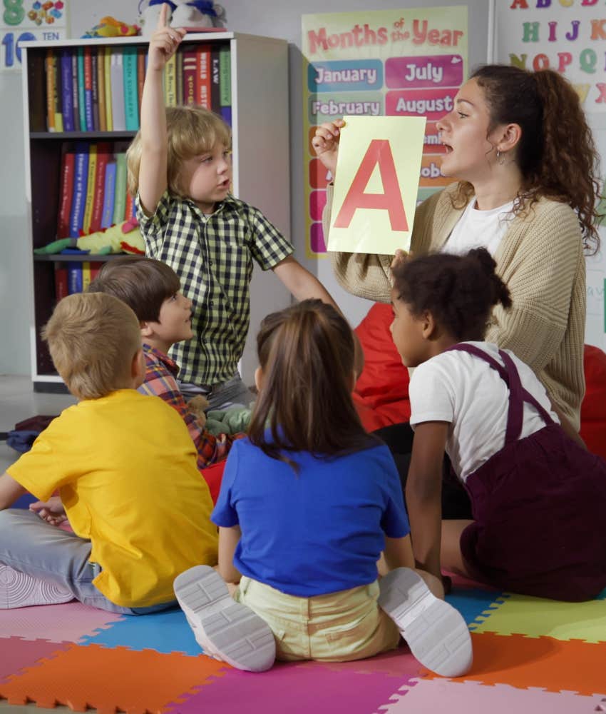 Daycare teacher helping kids with alphabet