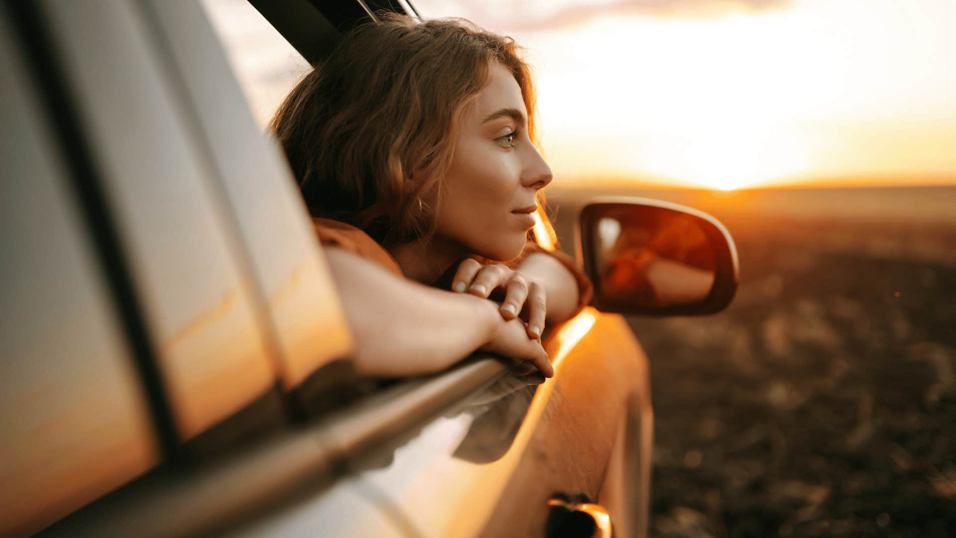 woman in car watching sunset