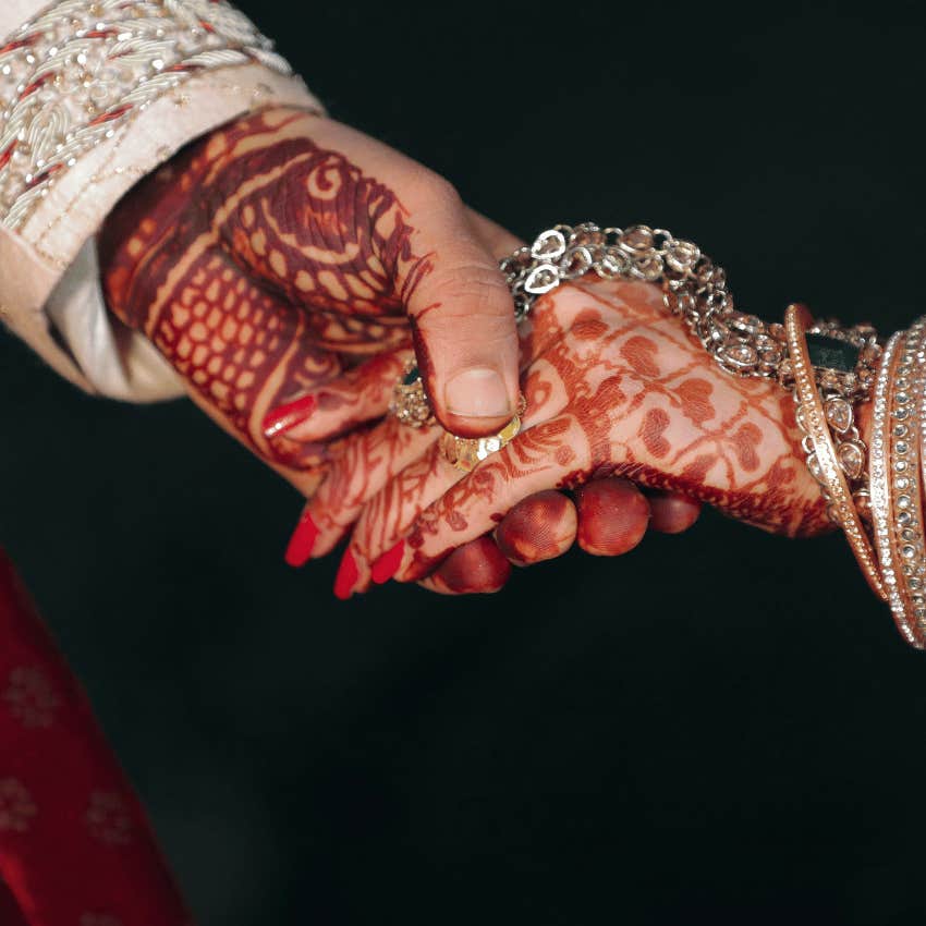 desi couple with henna holding hands