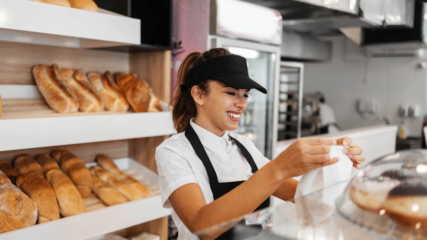 fast food bakery worker handing bag to customer