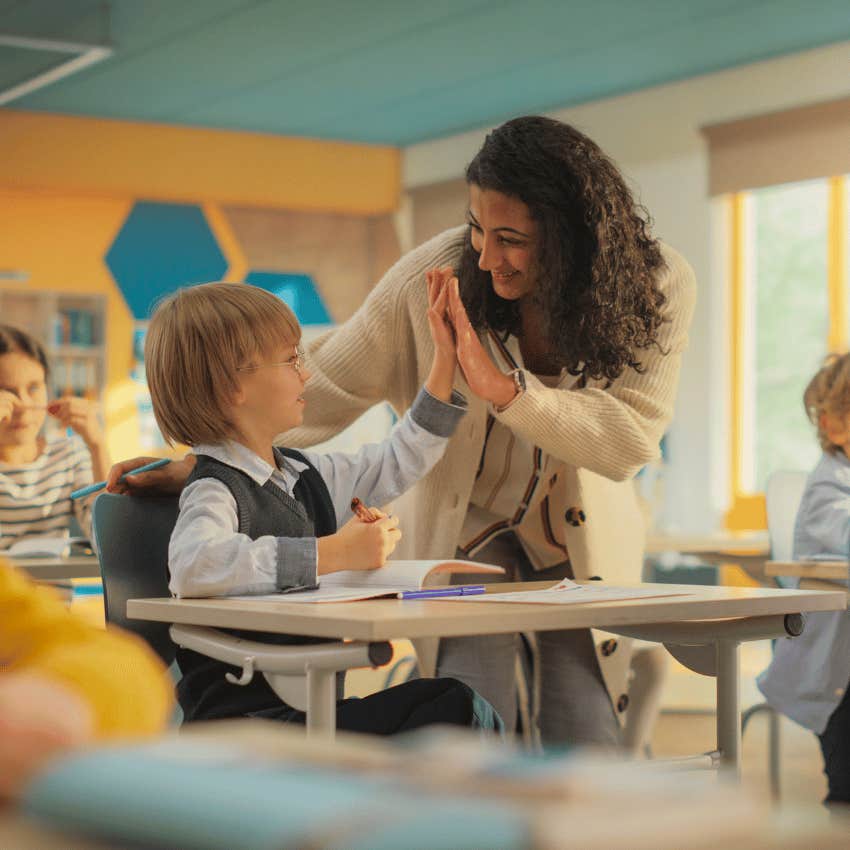 female teacher giving young boy a high five