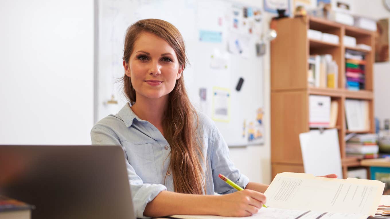 Teacher sitting at her desk in classroom