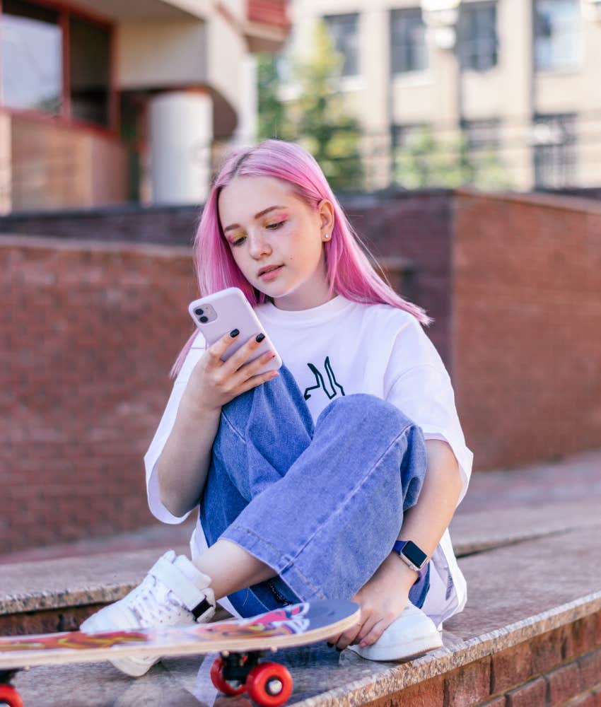 Gen Z girl with pink hair scrolling social media