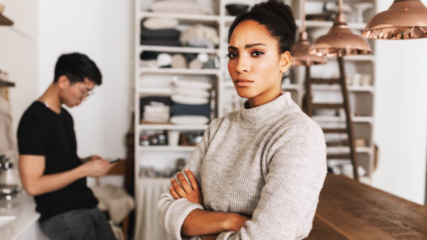 Woman feeling disrespected by partner, arms crossed.