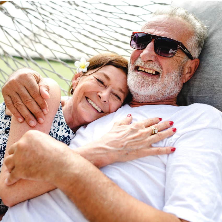 Nursing home couple laying together and smiling. 