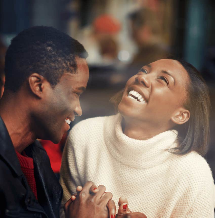 Exuberant couple hold hands and smile