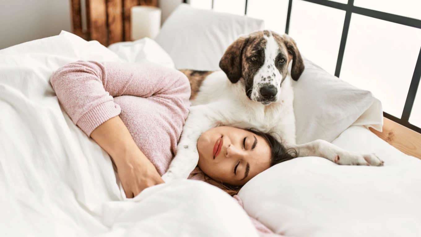 Woman sleeping with happy dog