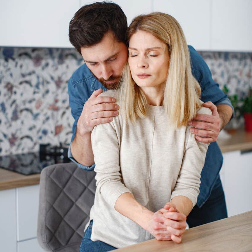 husband holds and consoles emotional wife at home