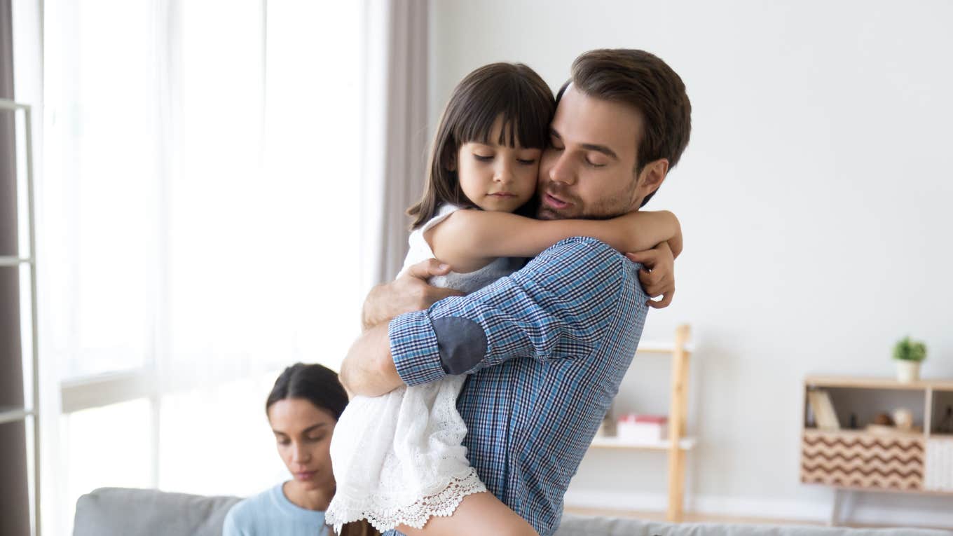 Dad hugging daughter after being yelled at by mom