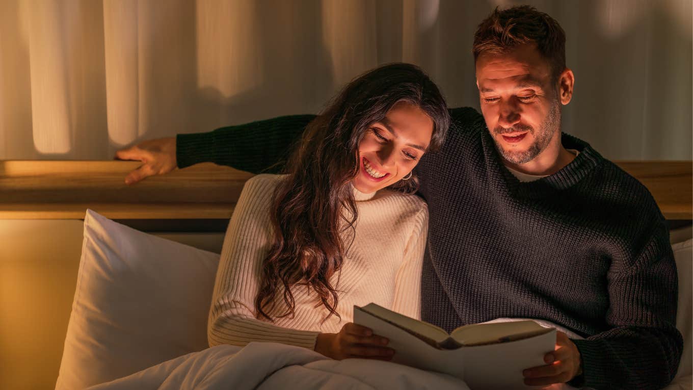 happy couple reading together in bed