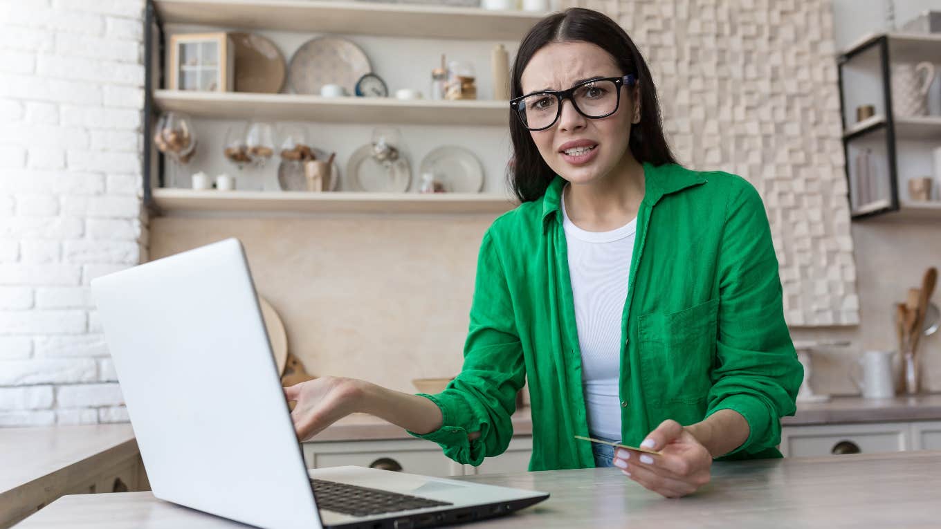 Upset worker reading email from job about paychecks