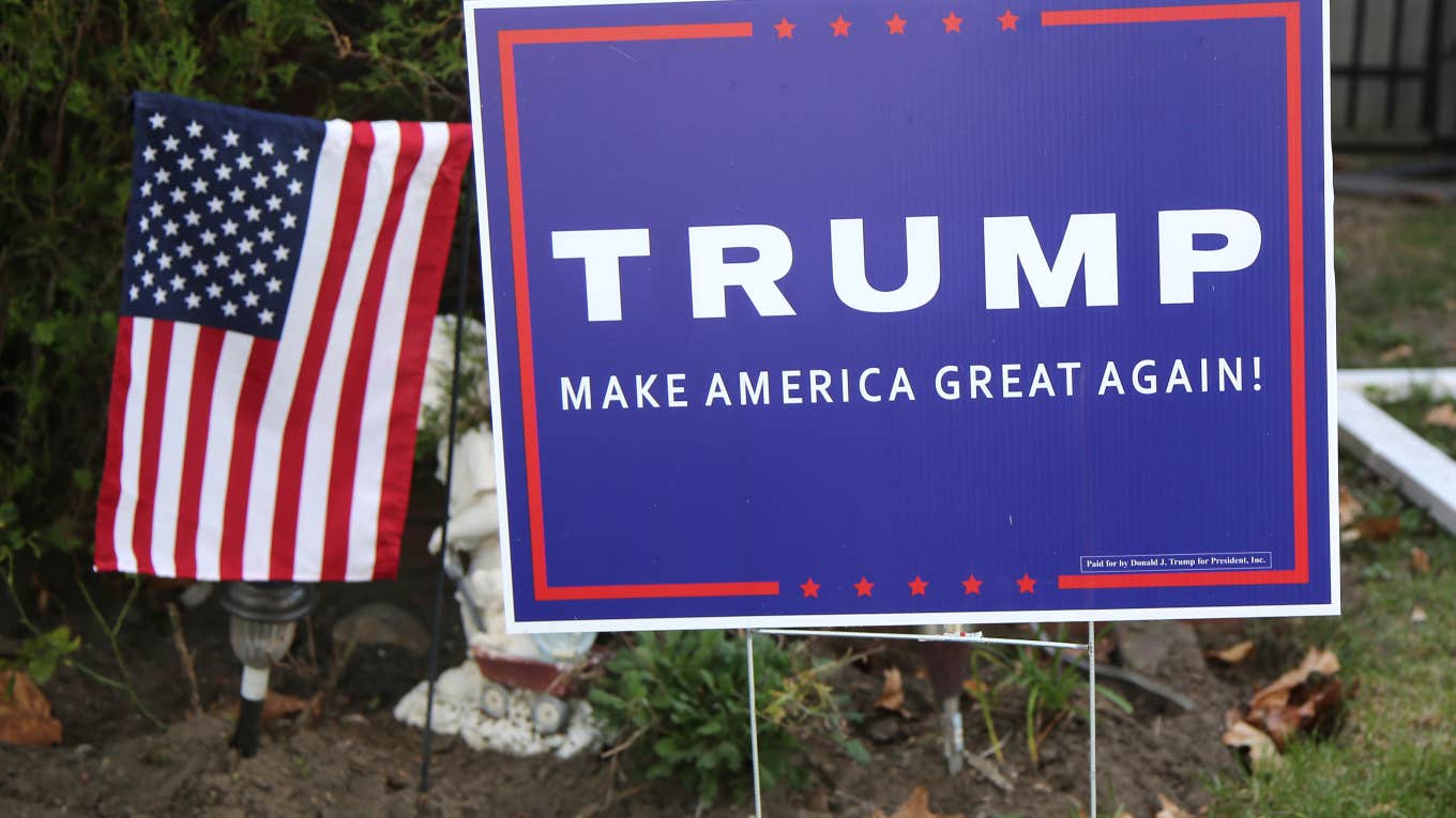 Trump yard sign next to American flag