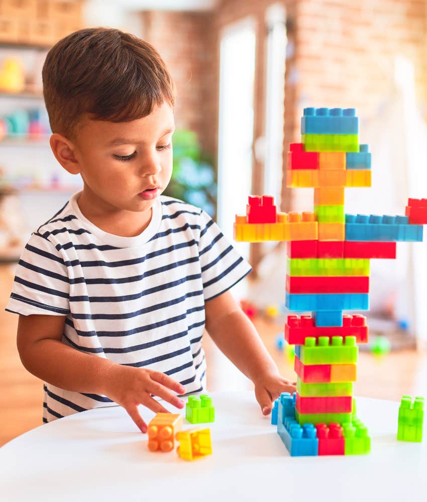 Little boy playing Legos alone