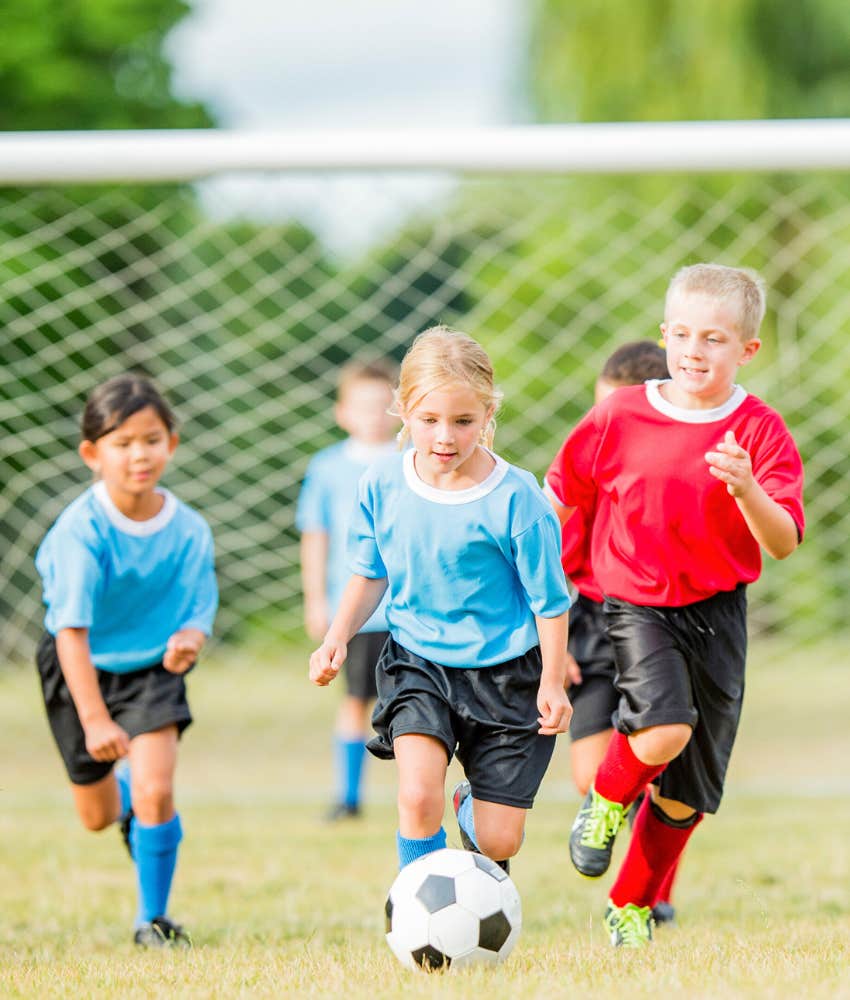 little girl playing soccer with boys