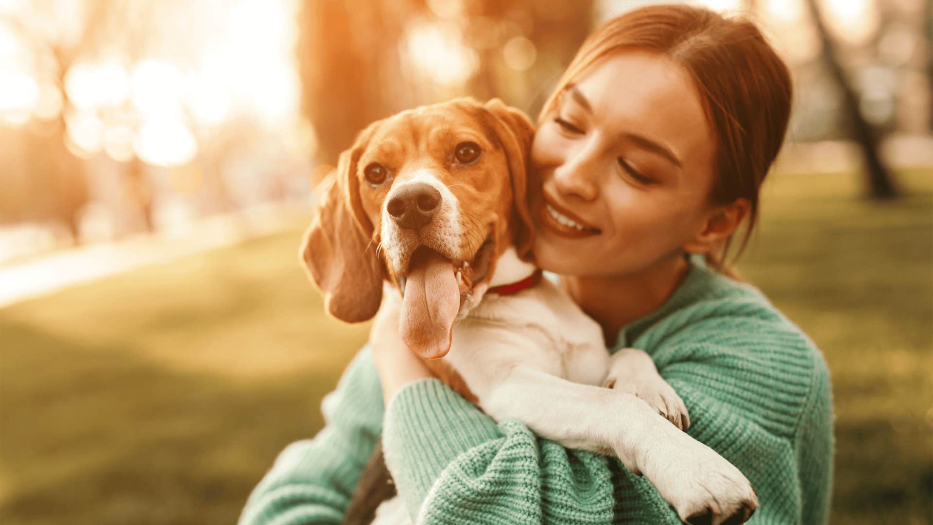 woman holding dog while smiling 